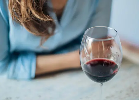 Femme devant un verre de vin rouge